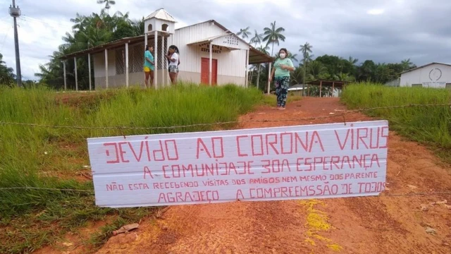 Placa diz: 'devido ao coronavírus a comunidade Boa Esperança não está recebendo visitasjogo do foguetinho blazeamigos nemjogo do foguetinho blazeparentes'