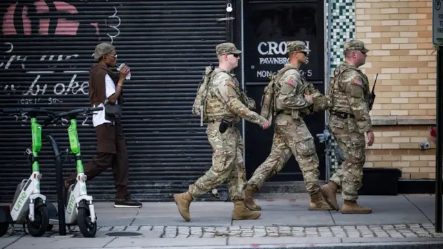 Трое мужчин в армейской форме шагают по улице Вашингтона