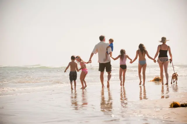 Une famille nombreuse se promène sur la plage