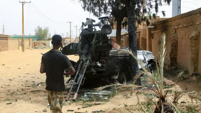 جندي من الجيش السوداني يسير باتجاه مدفع مثبت على شاحنة تركته قوات الدعم السريع شبه العسكرية في مدينة صالحة، جنوب أم درمان، بعد يوم من استعادته من قوات الدعم السريع، في 21 مايو/أيار 2025. وكان الجيش السوداني قد أعلن في 20 مايو/أيار أنه طرد الفصائل شبه العسكرية المنافسة من آخر مواقعها في أم درمان، إحدى ضواحي العاصمة السودانية، ليضمن بذلك سيطرته على ولاية الخرطوم بأكملها بعد نحو شهرين من استعادة مركز العاصمة.