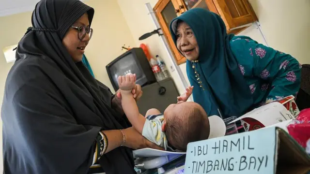 Petugas posyandu menimbang berat badan bayi di Posyandu Merak, Ciputat, Tangerang Selatan, Banten, Jumat (17/5/2024).