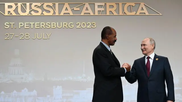 Isaias Afwerki serre la main de son homologue russe, Vladimir Poutine. Derrière lui, un panneau indique : « Russie-Afrique, Saint-Pétersbourg, 27-28 juillet 2023 ».