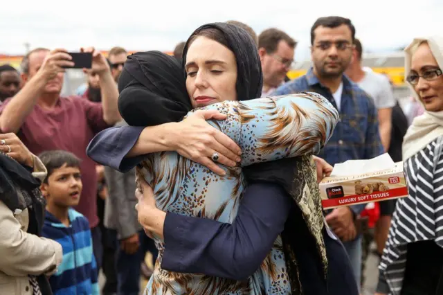 New Zealand Prime Minister Jacinda Ardern hugs a woman at the Kilbirnie Mosque, in Wellington, following mass shooting attacks in Christchurch. Fifty people died on 15 March when a white supremacist attacked two mosques while livestreaming on Facebook.