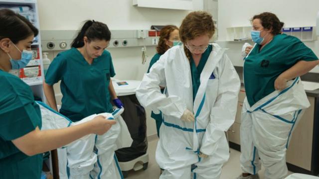 طبيبة وممرضات يرتدين ملابس وقاية ضد فيروس كورونا
