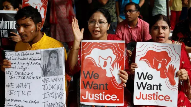 A group of protesters hold up signs demanding justice