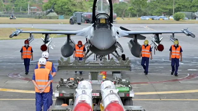 Air Force soldiers clear the ground in front of an armed F-16V fighter jet during a drill at Hualien Air Force base on August 17, 2022.