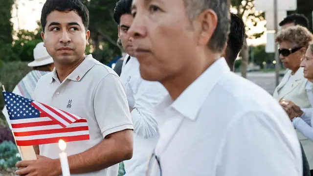 El Marine veterano Alejandro Barranco enfocado, sostiene una bandera de Estados Unidos durante una vigilia en honor a su padre, Narciso Barranco, y en protesta por las redadas migratorias del gobierno de Donald Trump, el 27 de junio de 2025 en Santa Ana, California, Estados Unidos. (Foto: Mario Tama/Getty Images)