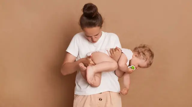 Una madre inspecciona el pañal de su bebé