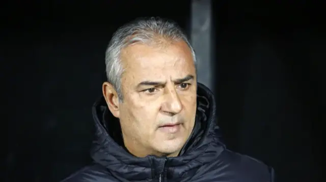 Siyah montlu beyaz saçlı bir adam