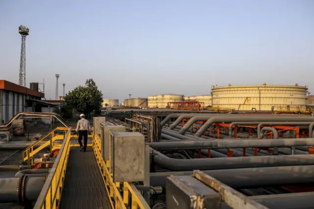 ગુજરાતના વાડીનારમાં આવેલ નાયરા એનર્જી લિમિટેડની ઑઇલ રિફાઇનરીમાં આવેલી પાઇપલાઇનો અને ટાંકા વચ્ચે ચાલી રહેલા એક કર્મચારીની એપ્રિલ 2018માં લેવાયેલી તસ્વીર