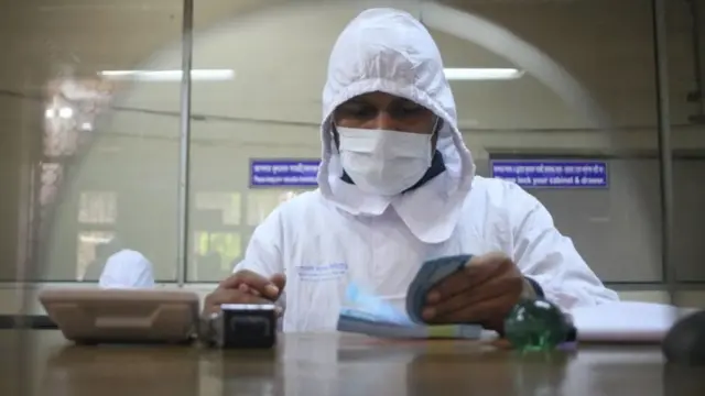 ভাইরাসের সংক্রমণ ঠেকাতে এভাবেই একজন ব্যাঙ্ক কর্মকর্তা কাজ করছেন।