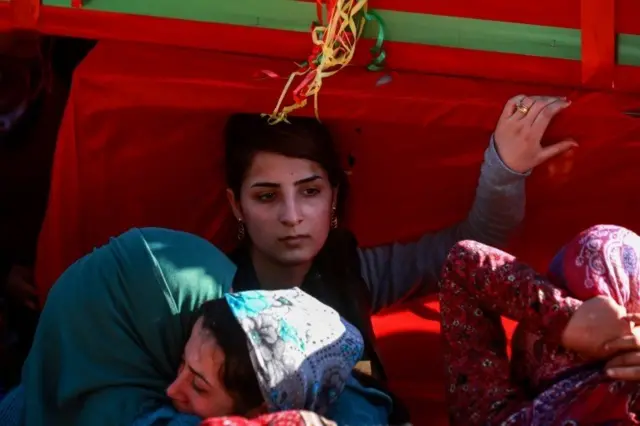 او در حال تشییع جسد سرباز یگان‌های مدافع خلق است که در جنگ عفرین کشته شده است