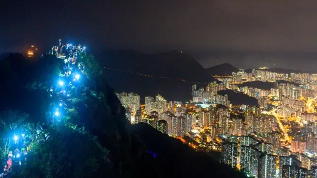 Участники акции зажигают фонарики на вершине Львиной горы