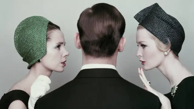 ผู้หญิง 2 คน ยืนประกบข้างผู้ชายที่หันหลัง