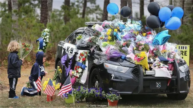 Meninos colocam flores na viatura do policial Sean Gannon, mortojogos online de navegadorabriljogos online de navegador2018