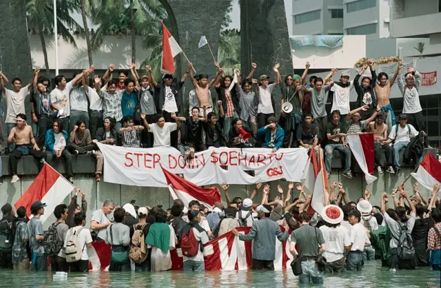 Mahasiswa demonstran dengan bendera dan spanduk selama protes di Indonesia, Mei 1998. Spanduknya berbunyi 'Mundur Soeharto'