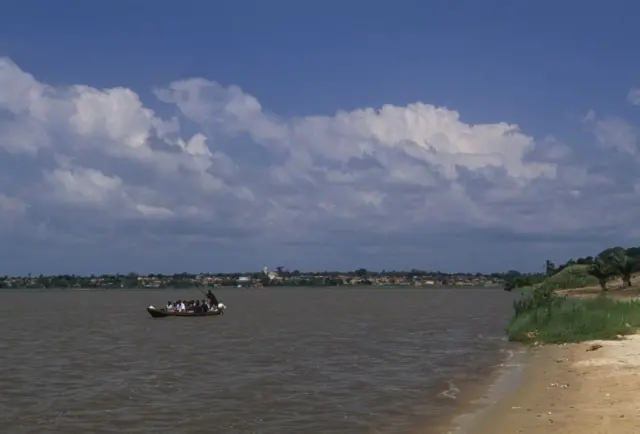Image montrant un lac avec une pirogue dans laquelle se trouvent des gens.