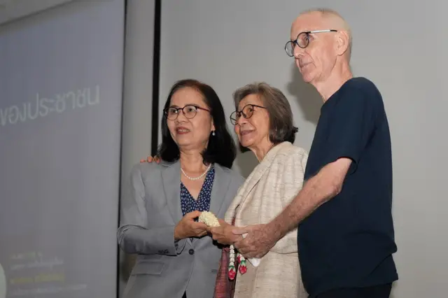 ก่อนงานเสวนาจะเริ่มต้นขึ้น ศ.ดร.ผาสุก พงษ์ไพจิตร และ ดร.คริส เบเคอร์ ร่วมมอบดอกไม้ให้กำลังใจ รศ.ดร.พวงทอง