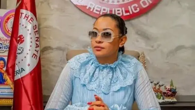 Sịnetọ Natasha yi ugeghe anya na uwe na-acha anụnụ anụnụ, ọkọlọtọ uhie dị ya n'akụkụ