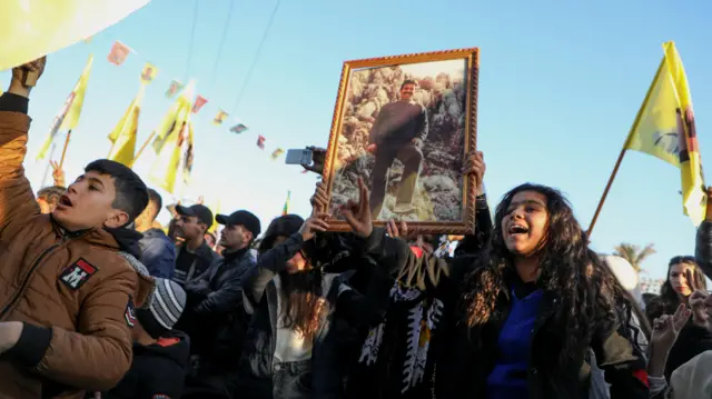 أكراد سوريون يحملون صورة لزعيم حزب العمال الكردستاني المسجون عبد الله أوجلان أثناء تجمعهم بعد أن دعا إلى إلقاء السلاح يوم الخميس، في الحسكة، سوريا. 
