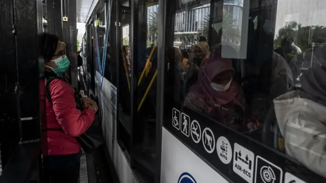 Warga menunggu kedatangan bus TransJakarta di Halte Tosari, Jakarta, Kamis (21/7/2022).