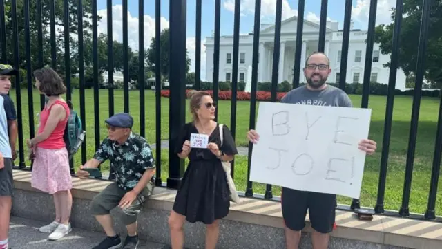 Людина з плакатом "До побачення, Джо!"