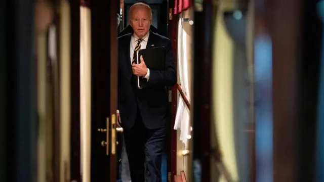 El presidente Joe Biden camina por un pasillo hasta su cabina en un tren después de una visita sorpresa al presidente ucraniano Volodymyr Zelenskiy.