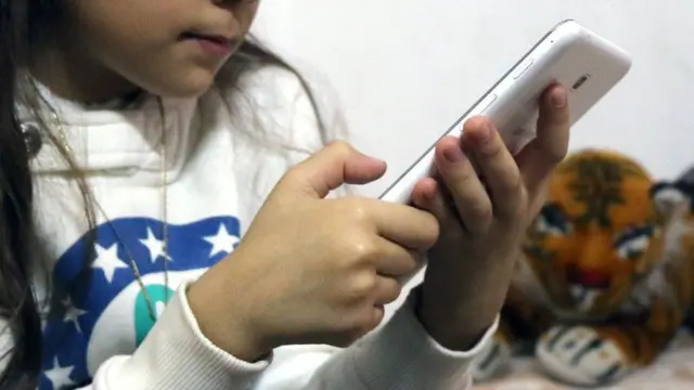 સ્માર્ટફોનનો ઉપયોગ કરતું બાળક