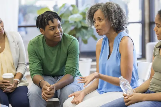 Jóvenes conversan con adultos.