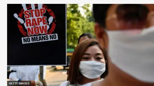 Aworan to n tako ifipabanilopọ, ọmọbinrin kan lo gbe patako ọhun dani.