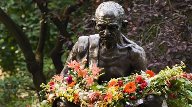 महात्मा गांधीजींच्या पुतळ्यावर पुष्प