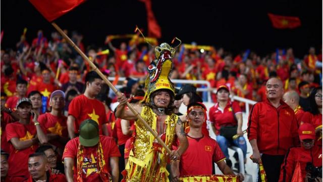Cổ động viên Việt Nam đội chiếc mũ hình đầu rồng trong trận bán kết AFF Suzuki Cup 2018 giữa Việt Nam và Philippines trên sân vận động Mỹ Đình