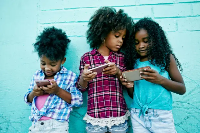 Small girls dey press dia fones