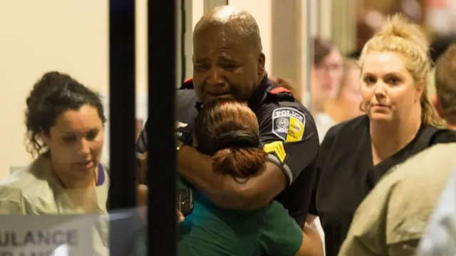 Un policía de la unidad de tránsito llora en la entrada de la emergencia del Hospital Universitario Baylor.