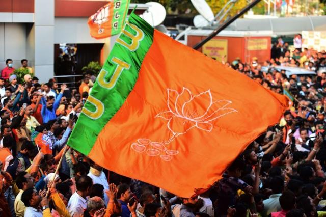 Apoiadores agitam uma bandeira do BJP em um comício em 2022