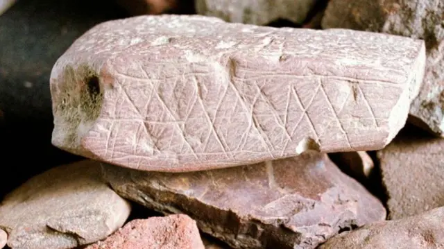 Imagem de uma coleção de fragmentos de ocre (hematita, óxido de ferro) encontrados durante escavações na caverna de Blombos, na África do Sul