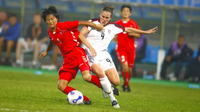 Heather O'Reilly disputando a bola durante partida contra Coreia do Norte.