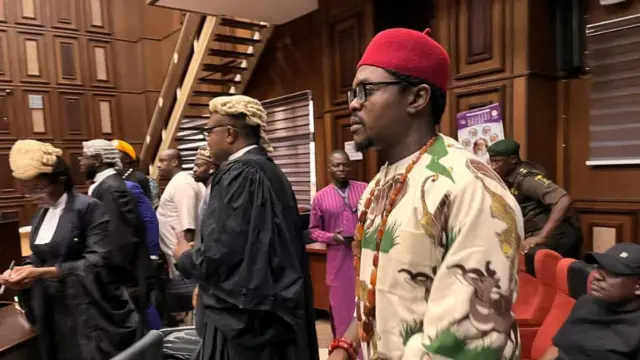 Blord yi uwe nwere agwa ma kpuru okpu agọrọ na-acha uhie uhie nọrọ n'ime ụlọikpe.