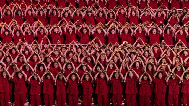 Around 1,000 students sing patriotic songs at an event to celebrate the 75th anniversary of China's National Day in Hong Kong, China, September 30, 2024. REUTERS/Tyrone Siu