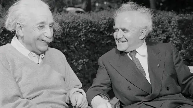 ሊቅ ፊዚክስ ኣልበር ኣይንስታይን ምስ ፈላማይ ቀደማይ ሚኒስትር እስራኤል ዴቪድ ቤን-ጎሪዮን ብሓደ ኰፍ ኢሎም ዘርእይ ፃዕዳ ፀሊምን ዝሕብሩ ፎቶ