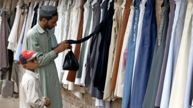 ਪਾਕਿਸਤਾਨ ਦੇ ਪੇਸ਼ਾਵਰ ਵਿੱਚ ਇੱਕ ਨੌਜਵਾਨ ਈਦ ਲਈ ਕੱਪੜੇ ਪਸੰਦ ਕਰਦਾ ਹੋਇਆ।