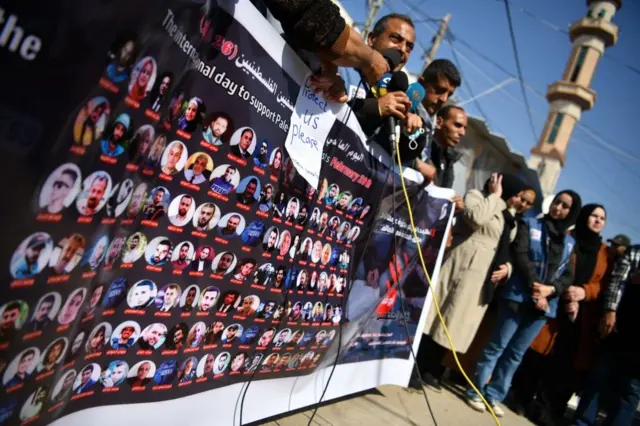 ग़ज़ा में इसराइली हमले में मारे गए पत्रकारों की फोटो के साथ प्रदर्शन करते फलस्तीनी पत्रकार