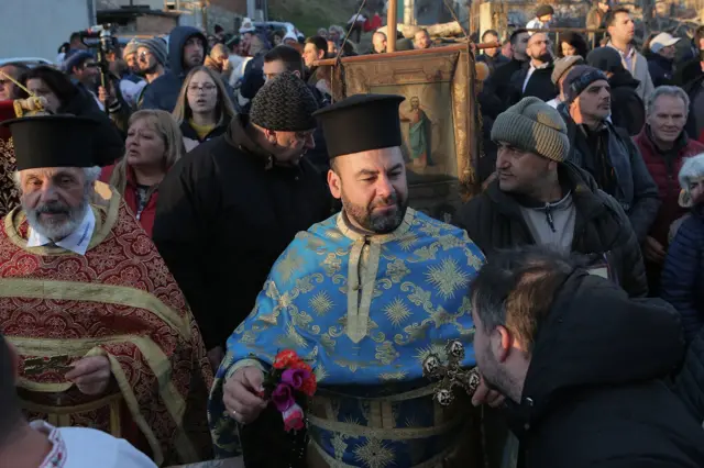 Nakon izlaska iz vode, sveštenici blagosiljaju učesnike svetom vodicom.