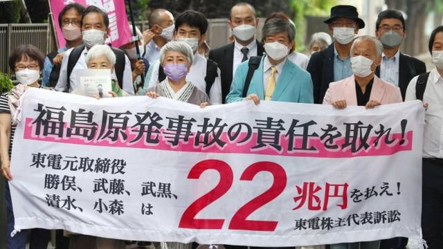 Plaintiffs in a lawsuit over Fukushima nuclear accident in 2011 walk toward Tokyo district court in Tokyo, Japan, 13 July 2022.