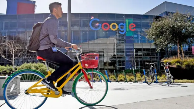 Una persona montando una bicicleta frente a las oficinas centrales de Google en Silicon Valley