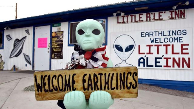 An alien-like statue displays a sign welcoming guests to the Little A'le' Inn restaurant and gift shop in Rachel, Nevada