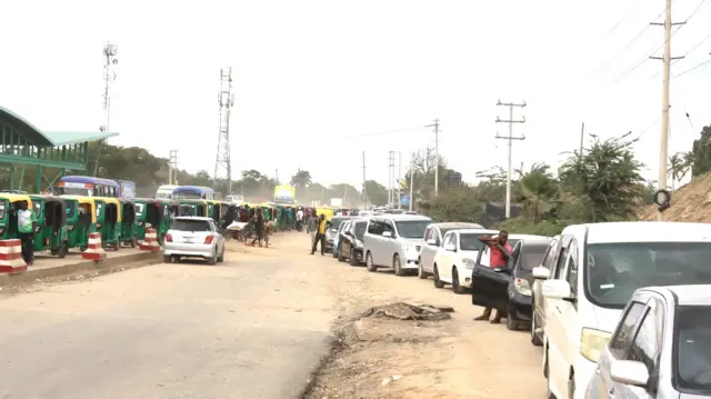 Imirongo ibiri y'ibinyabiziga - umwe w'ibinyabiziga bifite imipira itatu byitwa bajaji n'uwundi w'imodoka zisanzwe - bitegereje kumywa gaze