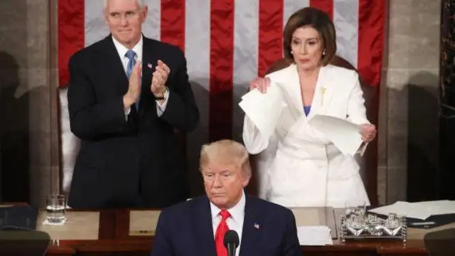 تصویر دونالد ترامپ در پیش زمینه، نانسی پلوسی با پیراهن سفید در سمت راست تصویر و مایک پنس معاون رئیس‌جمهور در قسمت راست تصویر. 