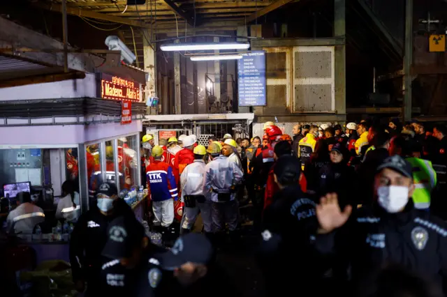 روغتیايي او امنیتي کسان د کان مخې ته د مرستې لپاره تیارسئ ولاړ دي