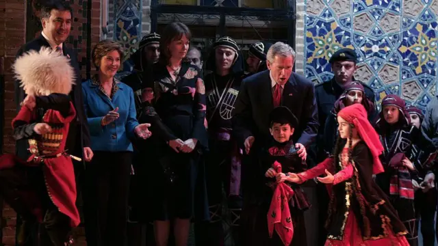 Джордж Буш смотрит грузинские танцы во время визита в Грузию в 2005 году